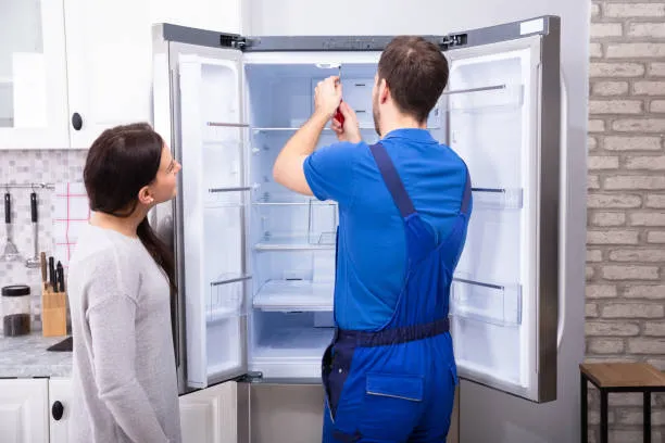 Reparación de refrigeradores LG; mujer observando como un técnico repara su equipo