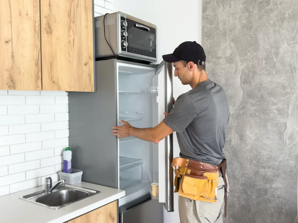 Técnico SERTEC revisando un refrigerador para ejemplificar ¿Por qué mi refrigerador LG no enfría pero sí prende? Causas y soluciones