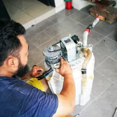 Técnico inspeccionando lavadora sin su carcasa como parte de la reparación de la lavadora Whirlpool en CDMX.